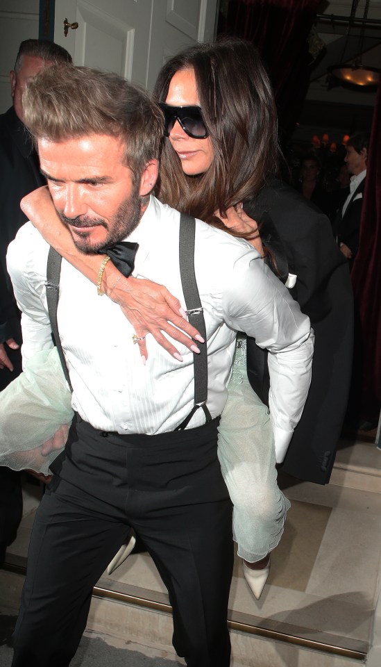 a man in a tuxedo is carrying a woman on his back