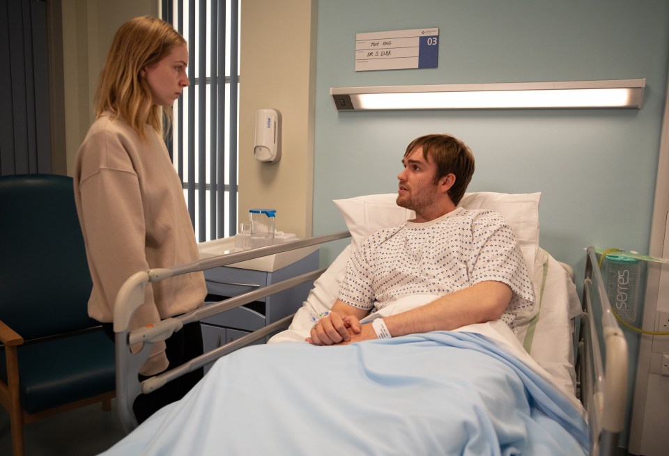 a woman stands next to a man in a hospital bed