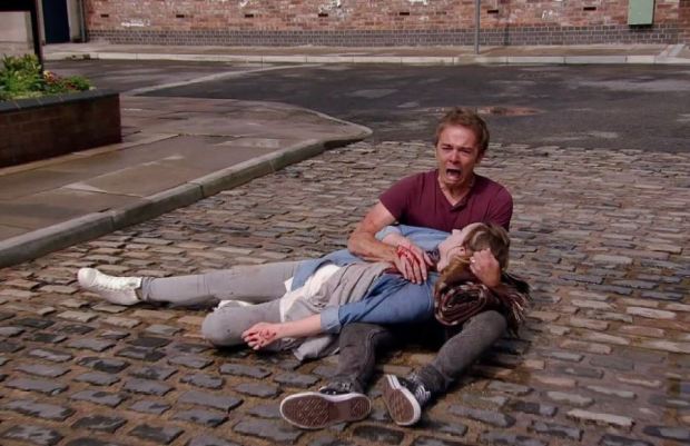 a man is holding a woman who is laying on the ground