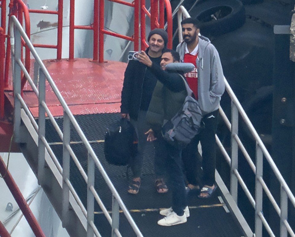 a group of people standing on a staircase with one wearing a sweatshirt that says ' abercrombie & fitch '