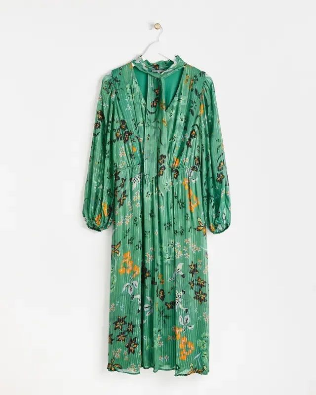 a green floral dress is hanging on a hanger