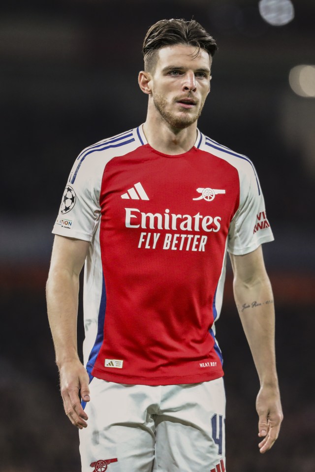 a soccer player wearing a red and white jersey that says emirates fly better