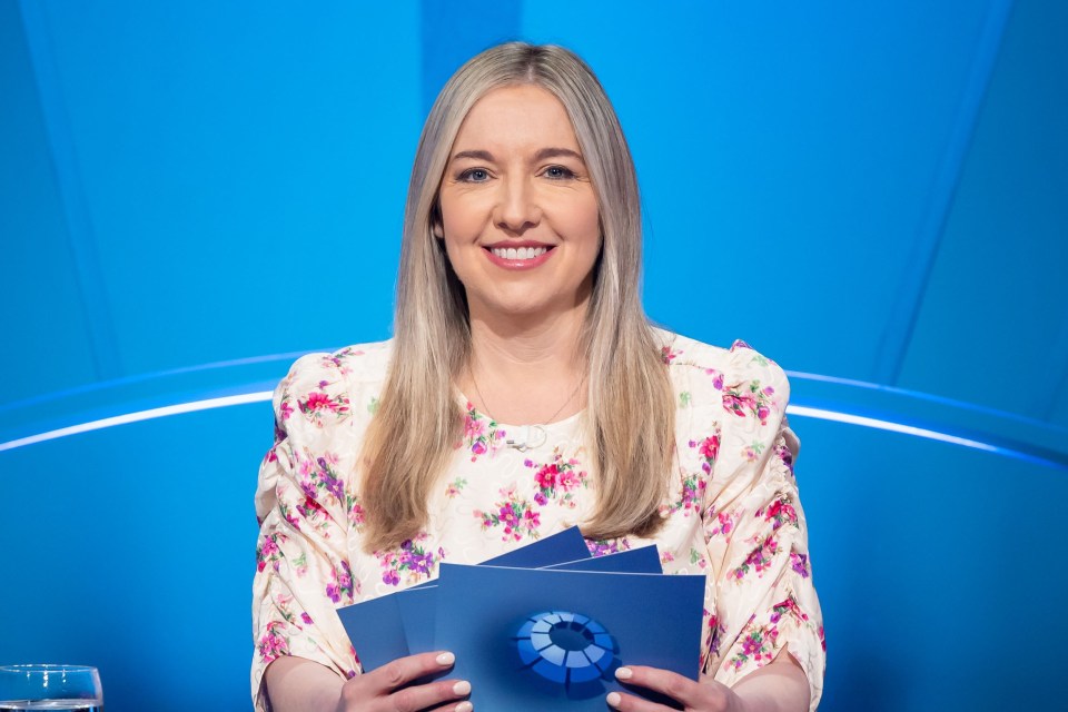 a woman in a floral shirt is holding a piece of paper with an eye on it