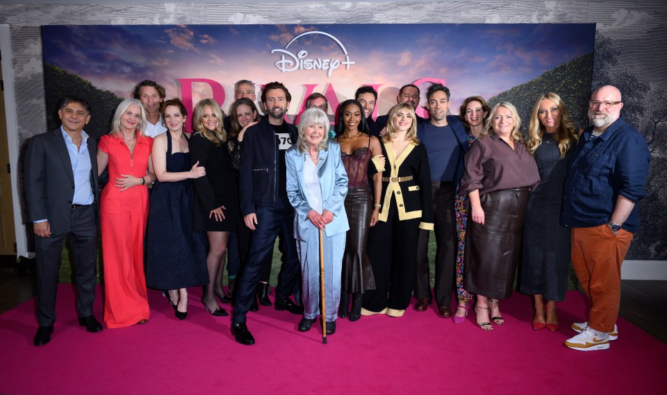 a group of people standing in front of a disney poster