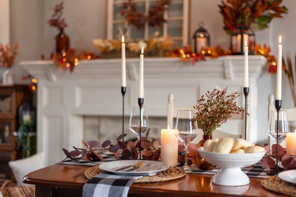 a table set for a thanksgiving dinner with plates and candles