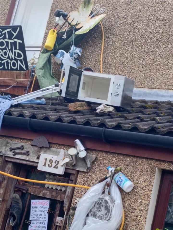 a microwave sits on a roof next to a sign that says city out crowd action