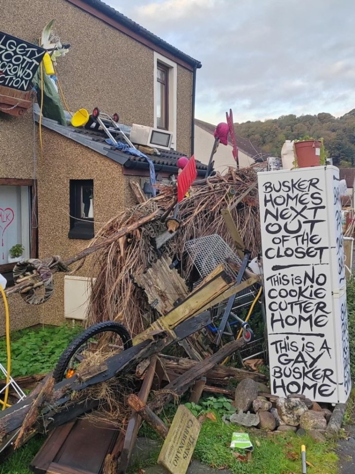 a pile of junk with a sign that says " busker homes next out of the closet "