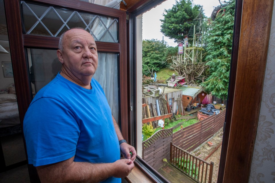 a man in a blue shirt is looking out a window