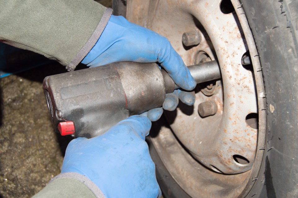 Mechanic unrecognizable working on car tire