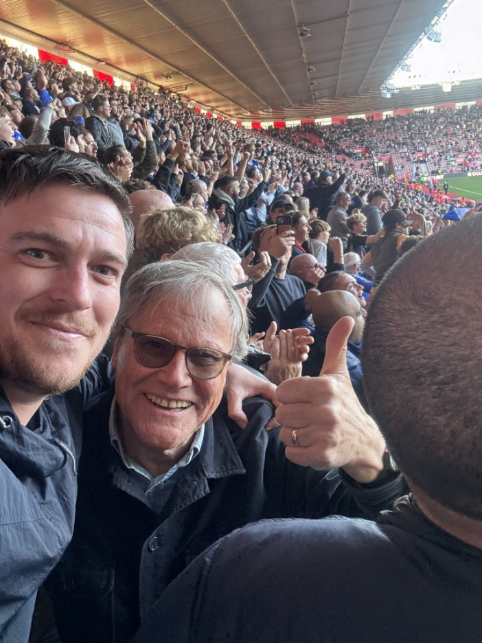 a man giving a thumbs up in a crowded stadium