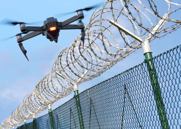 a drone is flying over a barbed wire fence