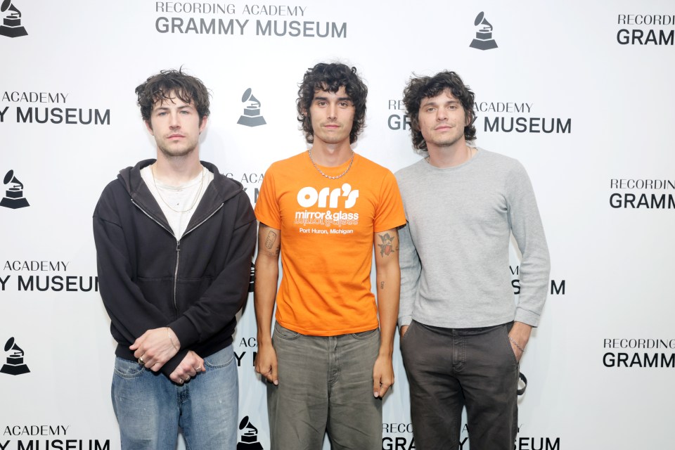 three men are standing in front of a wall that says recording academy grammy museum