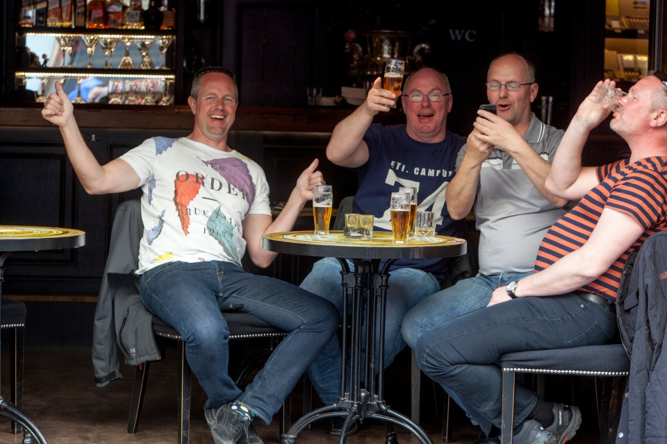 Male tourists in the city centre of Prague drinking both beer and spirits