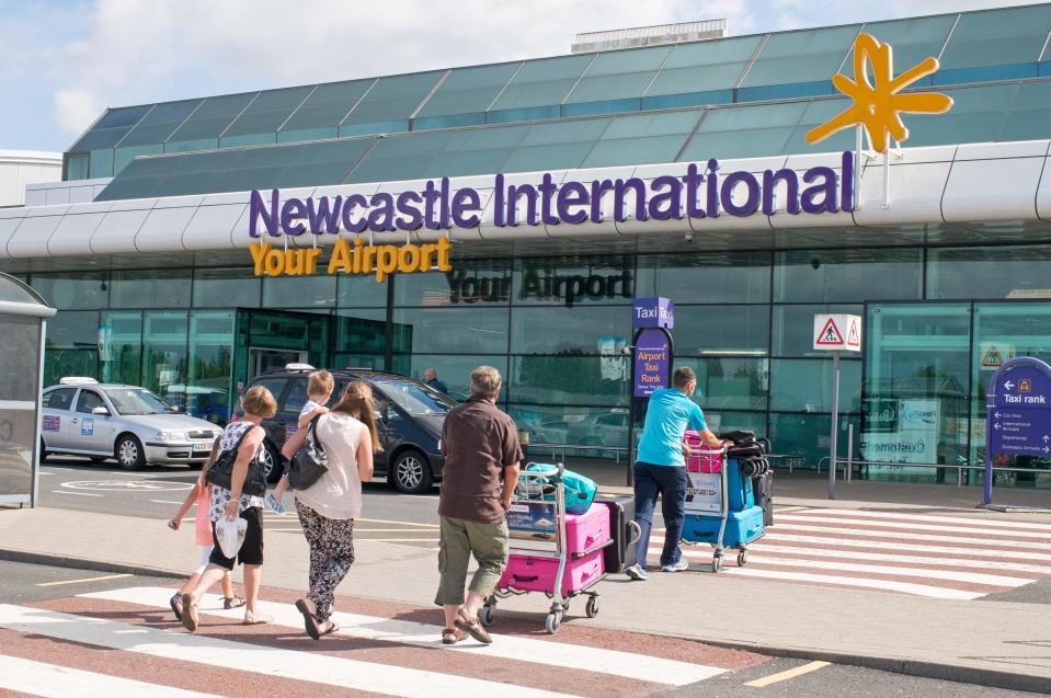 people walking in front of a building that says newcastle international