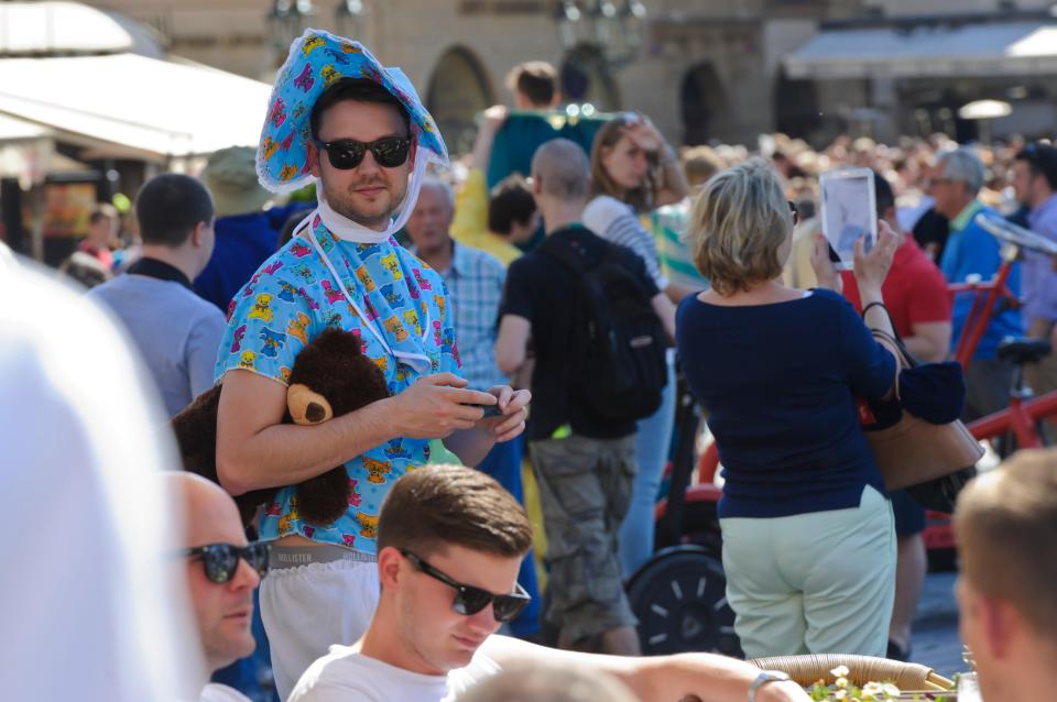 A man dressed in baby clothes and sunglasses celebrating his stag in Prague