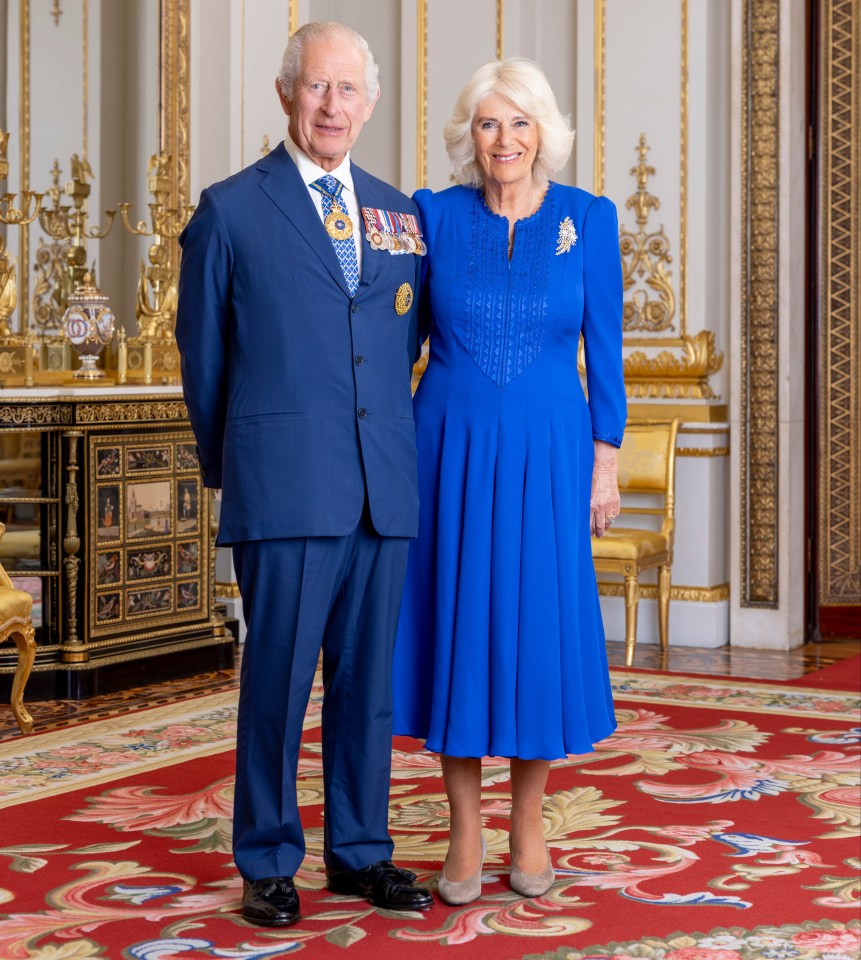 a man in a suit and a woman in a blue dress pose for a picture