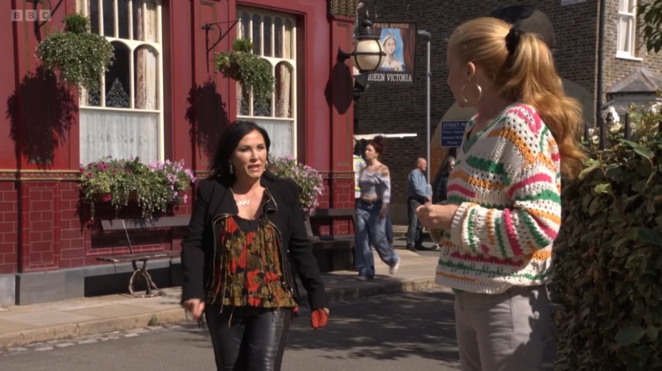 two women are standing in front of a building that says queen victoria