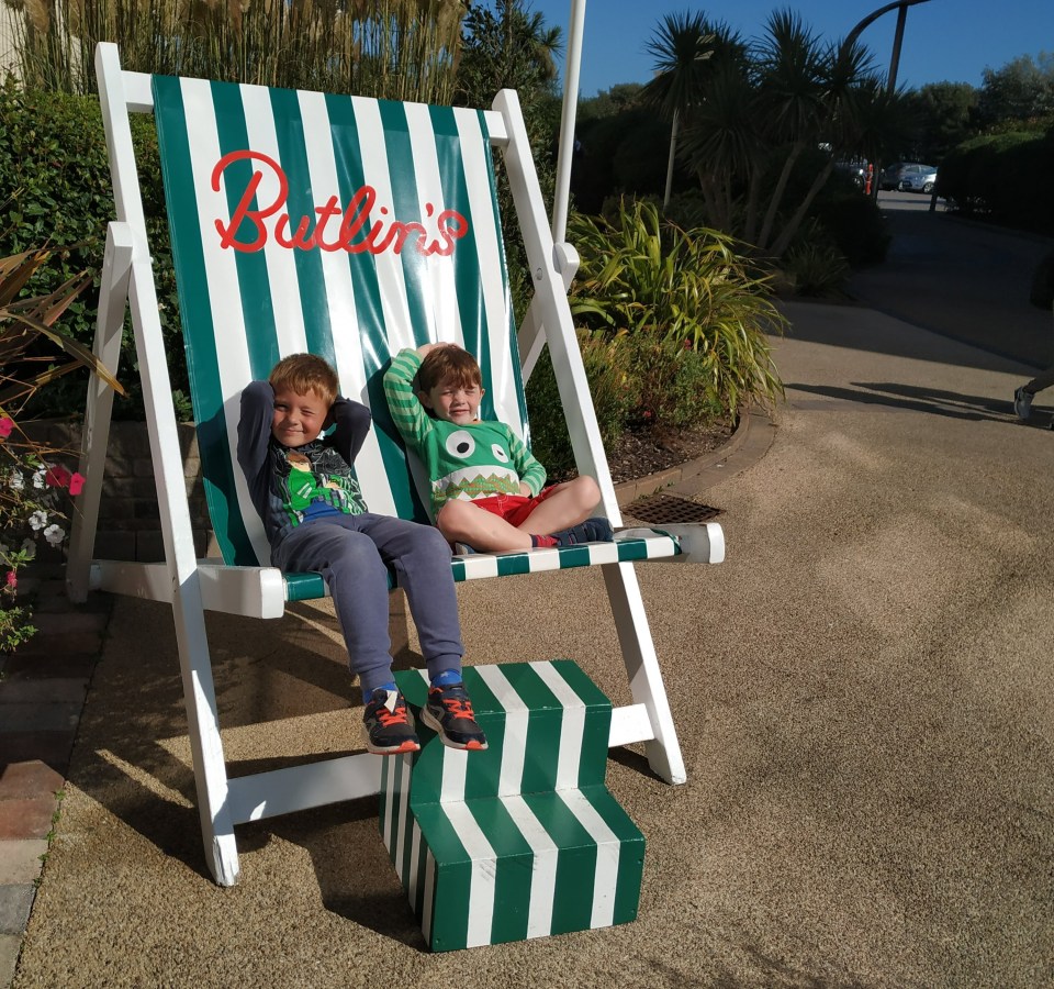 two young boys sit in a green and white striped chair that says pattin 's