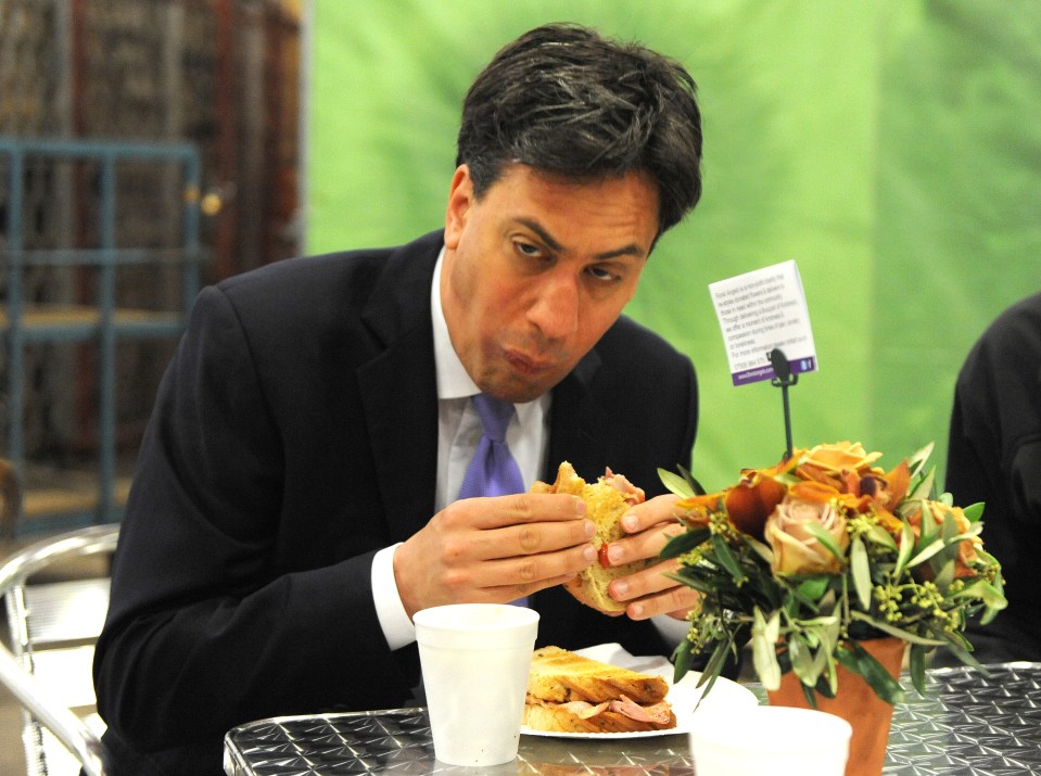 a man in a suit and tie is eating a sandwich