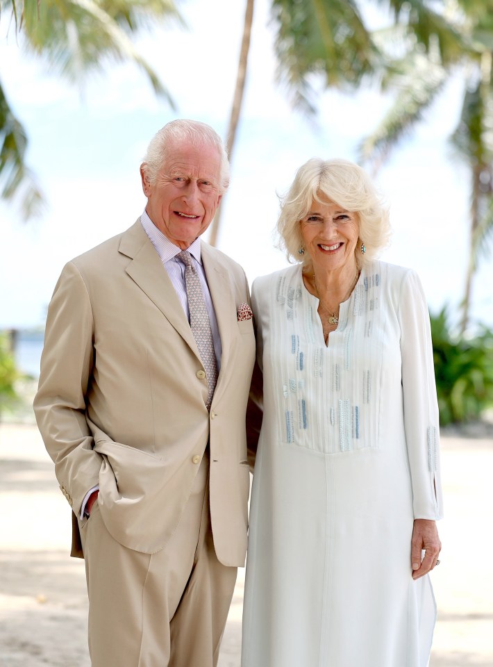 a man in a tan suit and tie stands next to a woman in a white dress