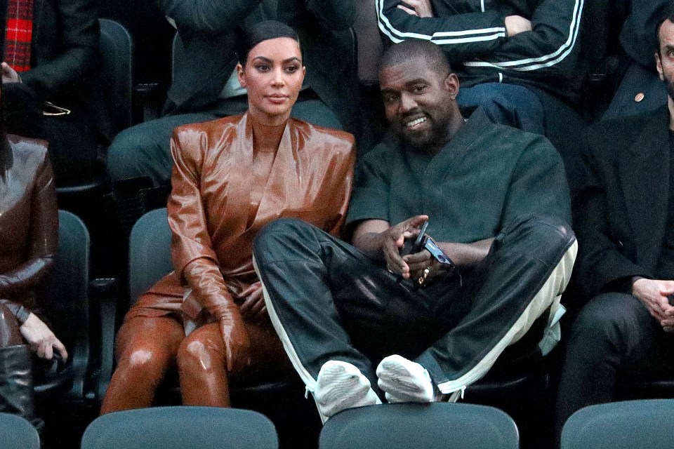 kim kardashian and kanye west sit in the stands at a basketball game