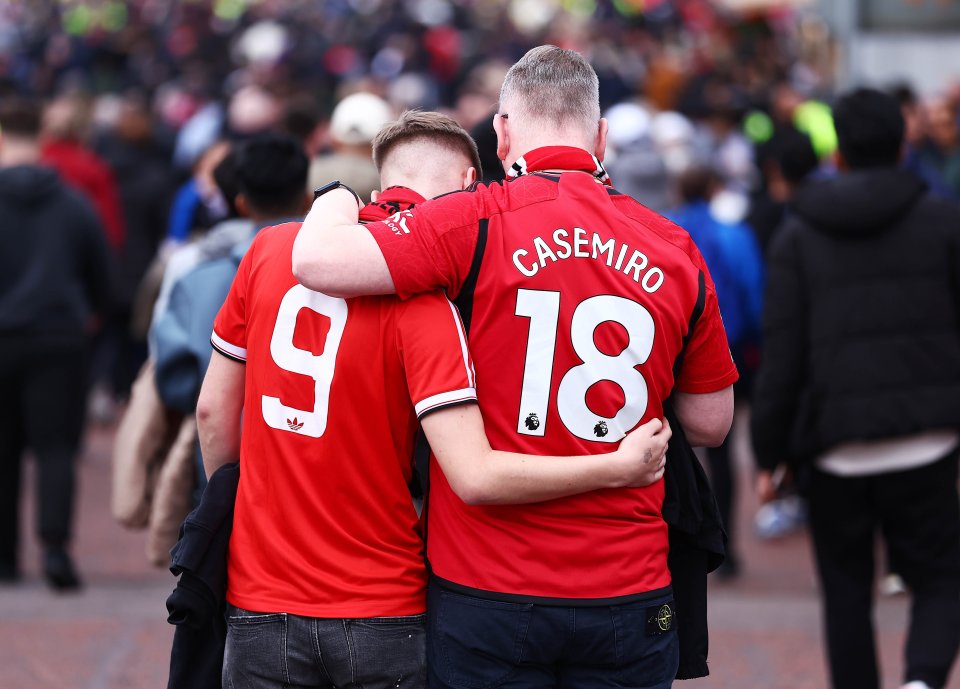 a man wearing a casemiro jersey hugs another man