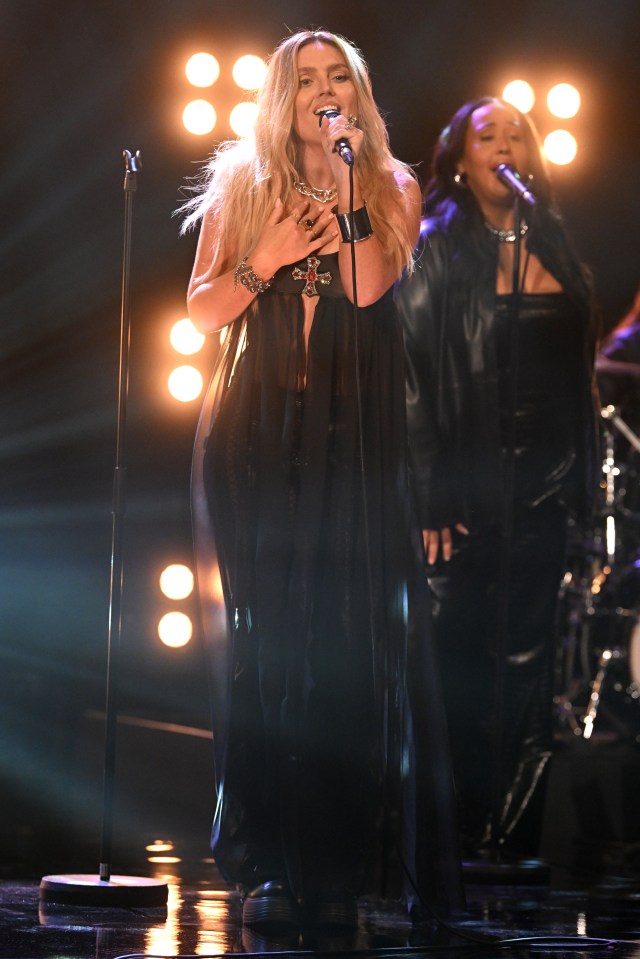 a woman singing into a microphone on a stage