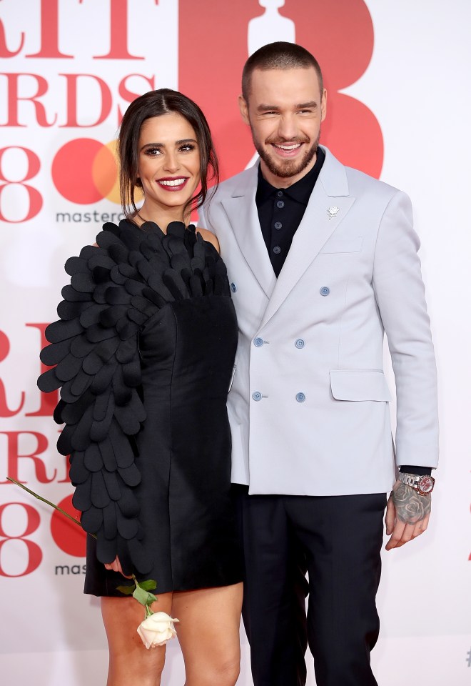 a man and a woman are posing for a picture on a red carpet that says mastercard on it