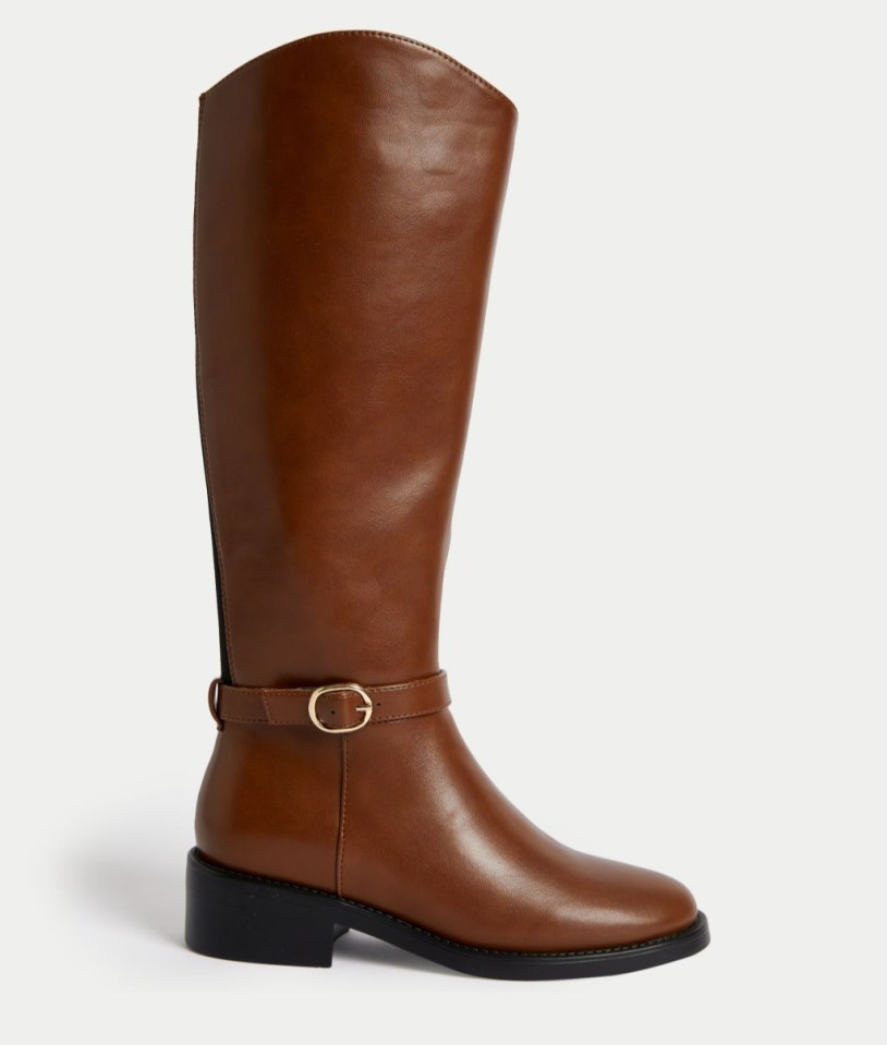 a pair of brown leather riding boots with a gold buckle