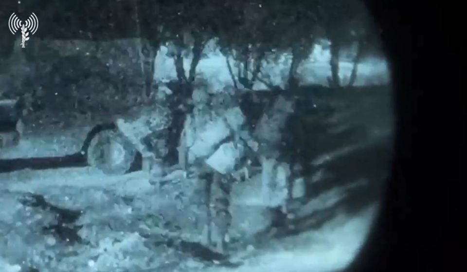 a group of soldiers are standing in the snow at night .