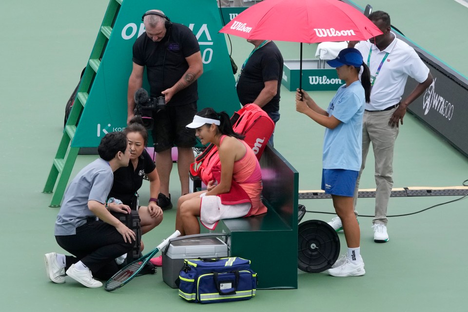 a woman sits on a bench under an umbrella that says wilson