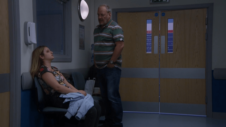 a man stands next to a woman in a hospital waiting room