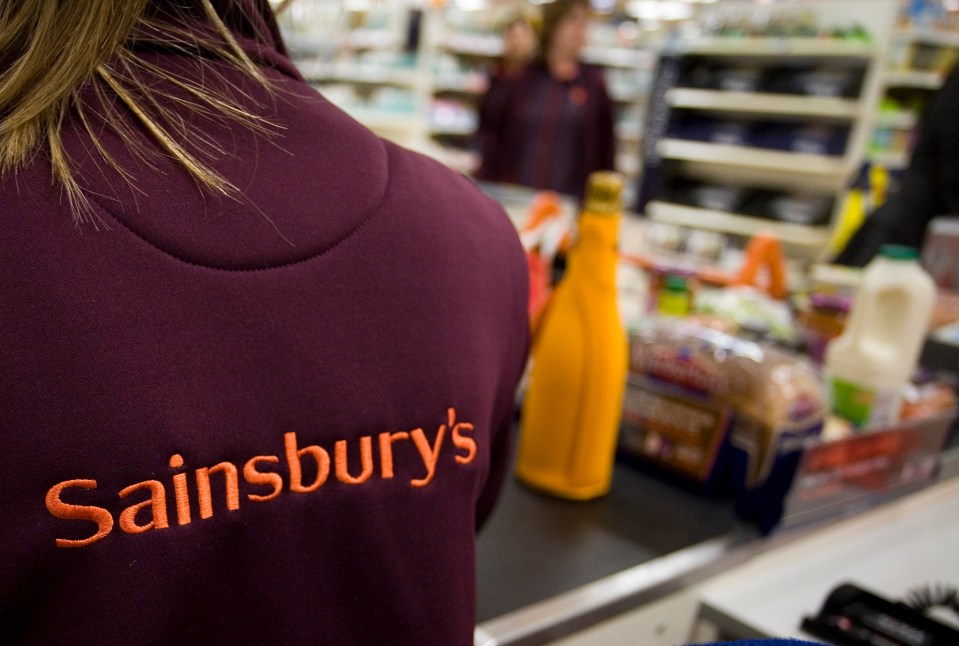 a woman wearing a sainsbury 's sweatshirt in a store