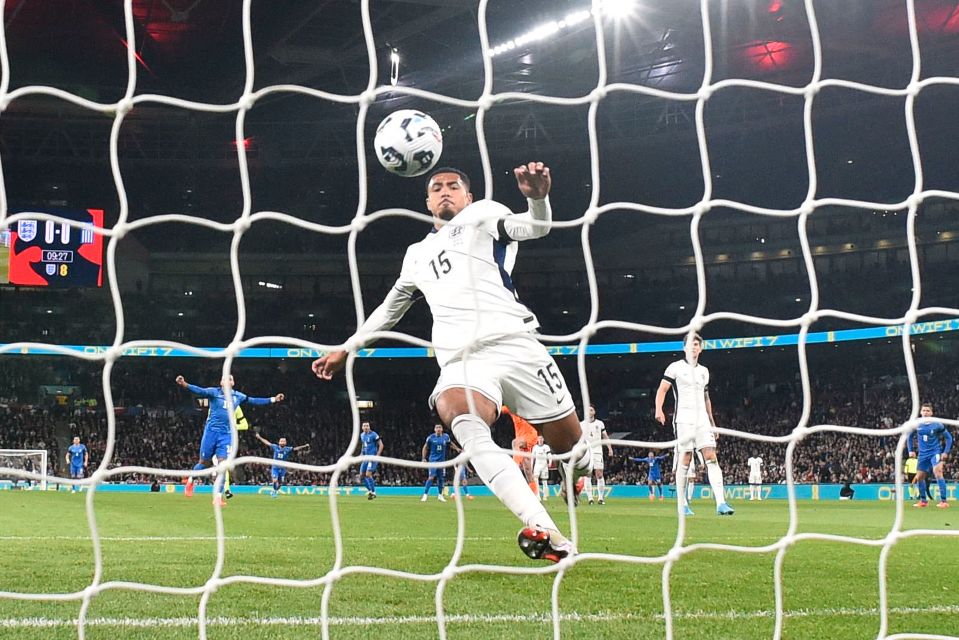 a soccer player jumps to catch a ball in front of a banner that says eaen 's reds