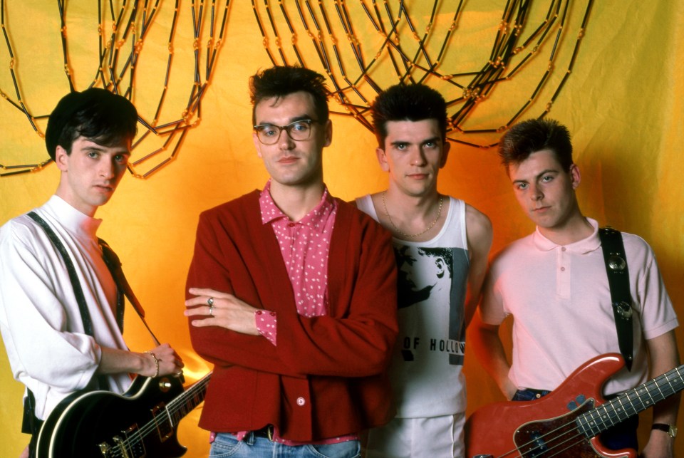 four men pose for a picture with one wearing a shirt that says of hollow