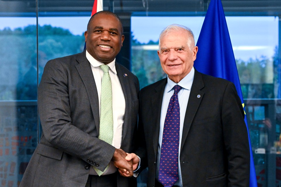 a man in a suit and tie shakes hands with another man