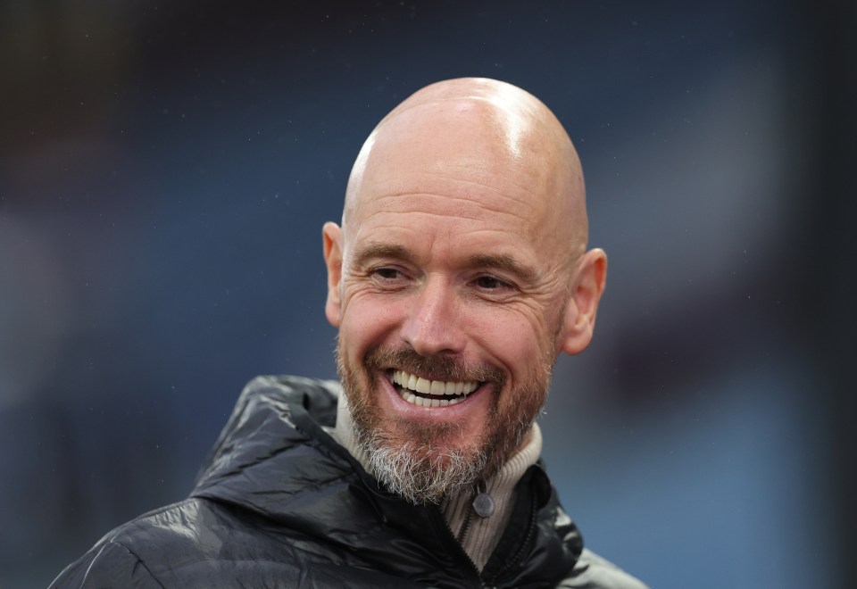 a bald man with a beard is smiling and wearing a black jacket