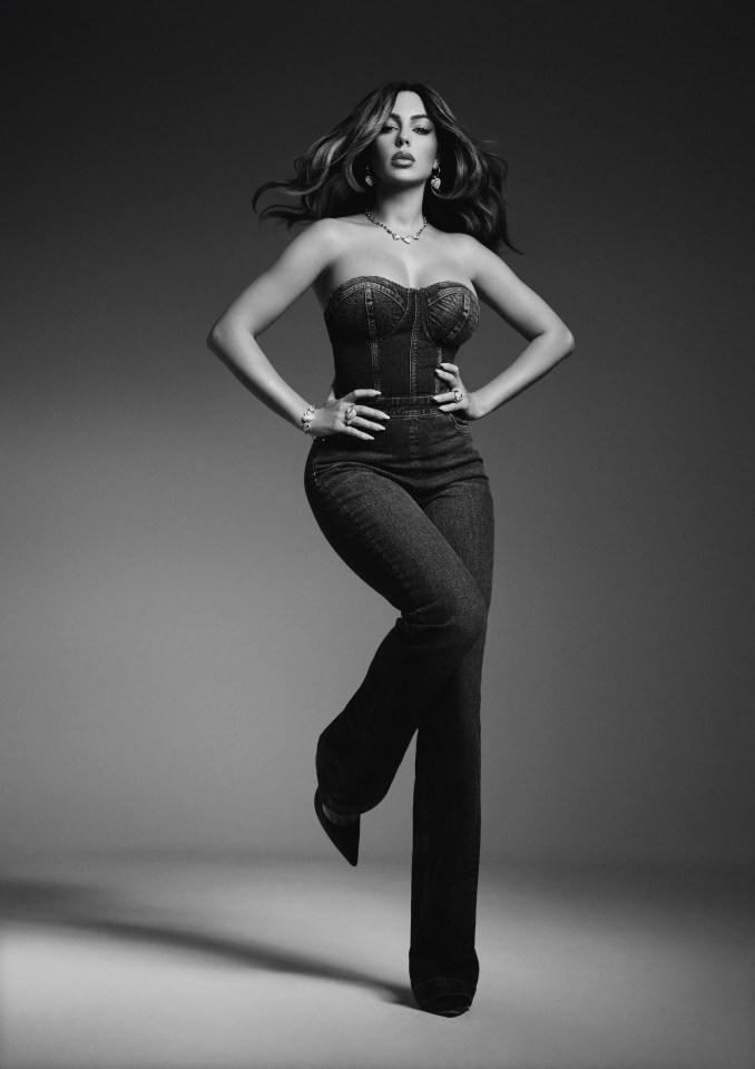 a black and white photo of a woman in a corset and jeans