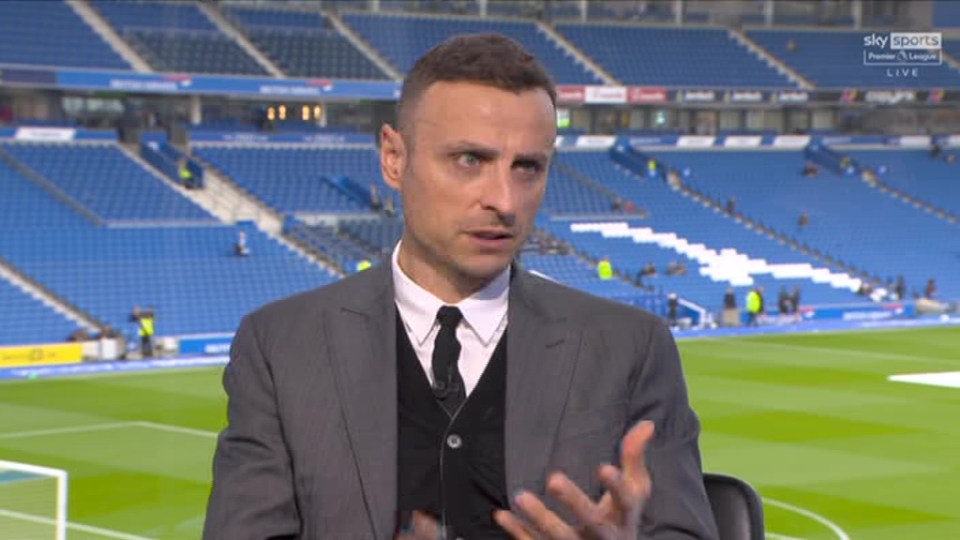 a man in a suit and tie is talking on a soccer field