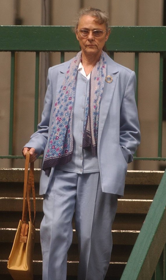 a woman in a blue suit and scarf is walking down stairs