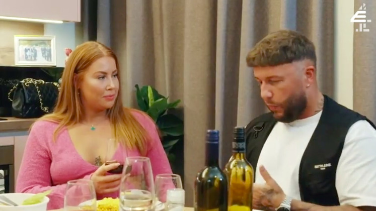 a man and a woman are sitting at a table with wine bottles .