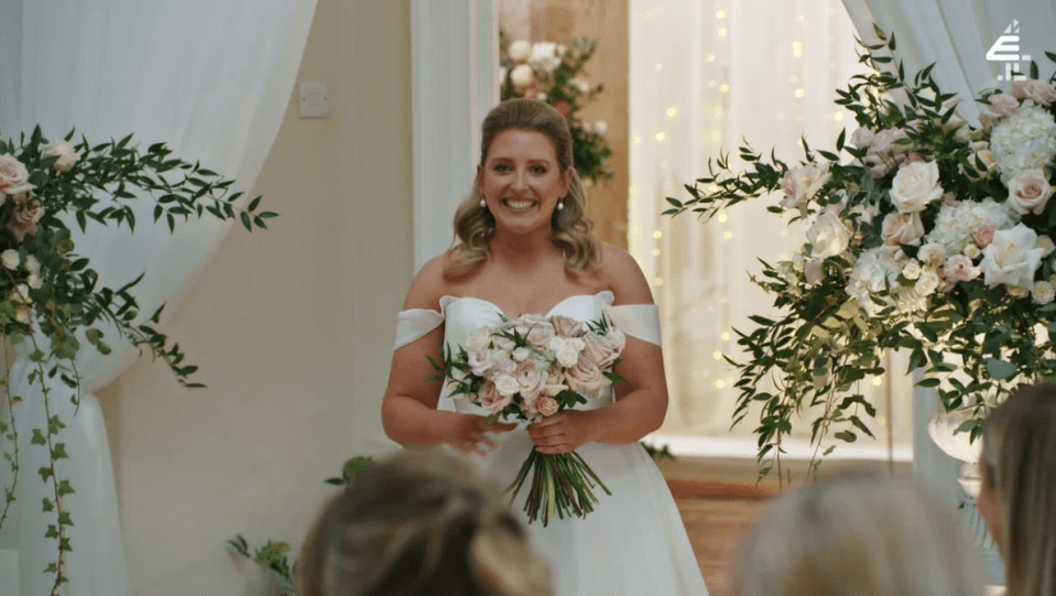 a woman in a wedding dress holds a bouquet of flowers