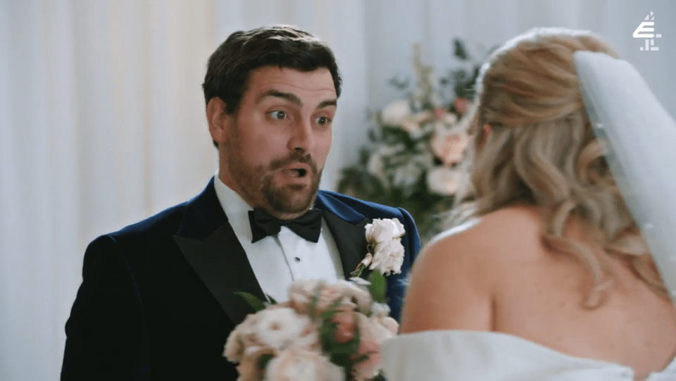 a man in a tuxedo stands next to a woman in a wedding dress