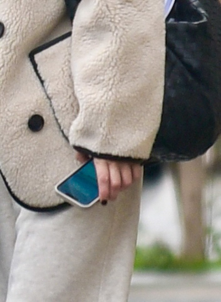 a woman is holding a cell phone in her hand