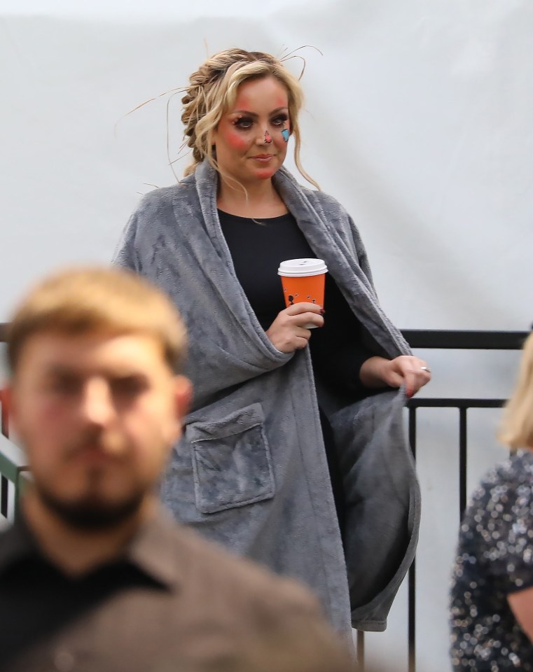 a woman in a robe is holding a cup of coffee