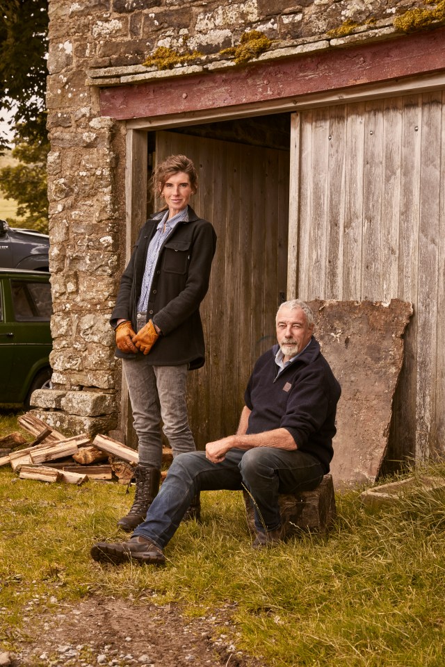 a man and a woman standing in front of a wooden building