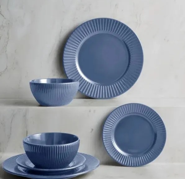 a set of blue plates and bowls on a marble counter top