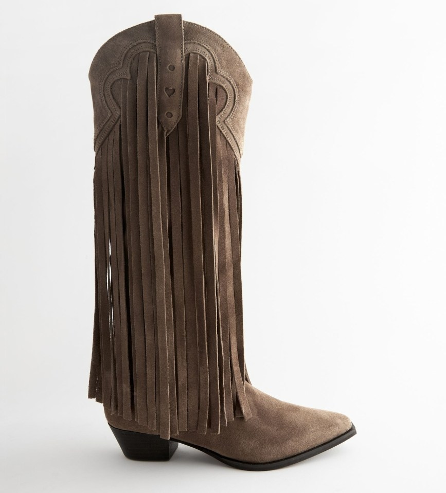 a pair of brown cowboy boots with fringe on the side