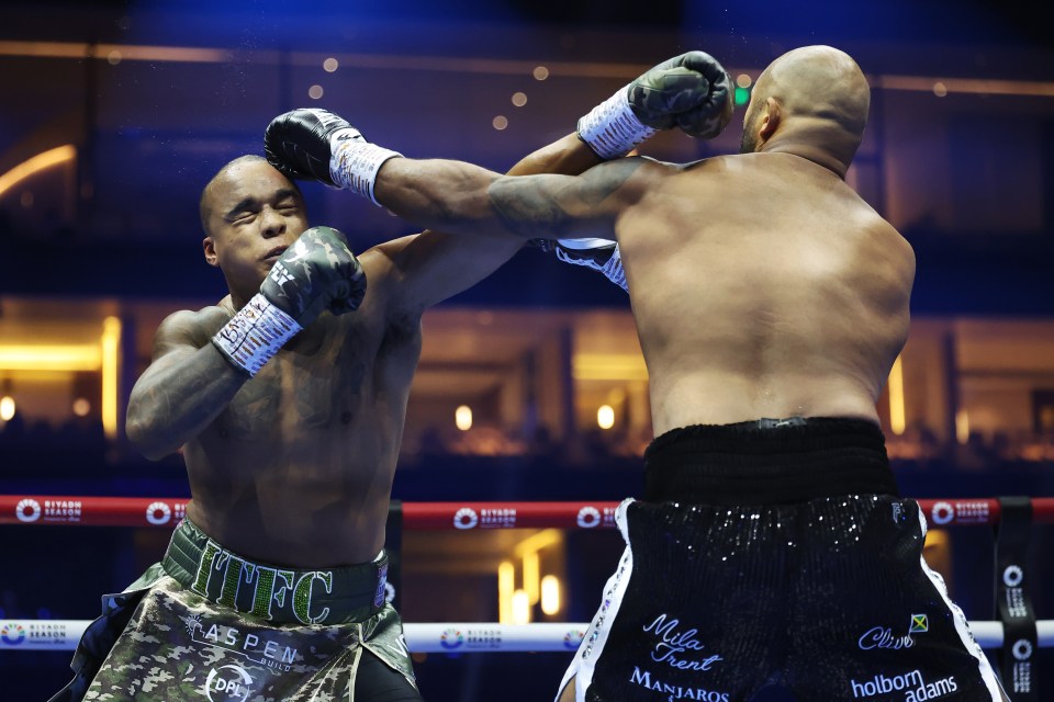 two boxers in a ring with one wearing a belt that says ufc