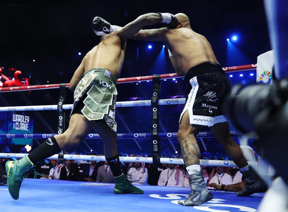 two boxers are fighting in a boxing ring with a sign behind them that says luxoleu & clarke